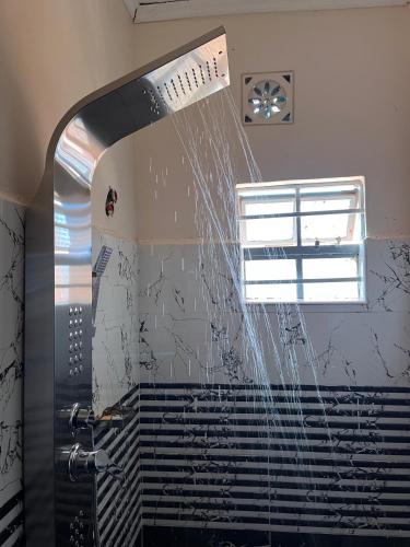 a shower with water coming out of the ceiling at Kristina Gardens in Voi