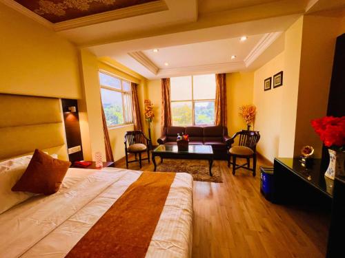 a bedroom with a bed and a living room at Hotel The Rio, Haridwar in Haridwār