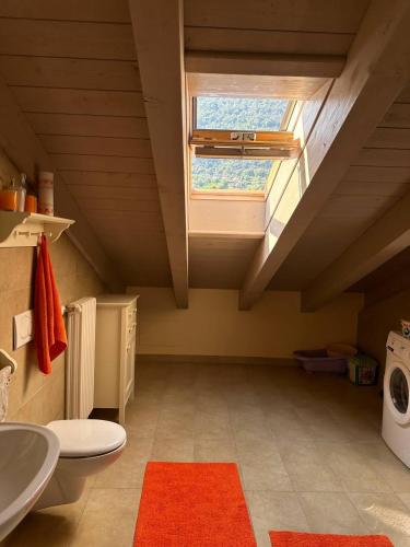 an attic bathroom with a toilet and a window at Duplex with terrace , pool, 2 bedrooms in Lenno