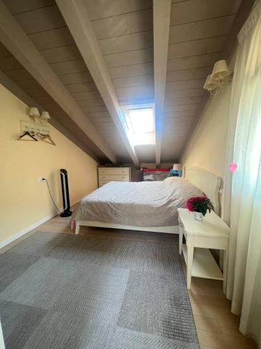 a attic bedroom with a bed and a window at Duplex with terrace , pool, 2 bedrooms in Lenno