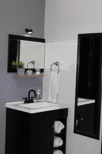 a bathroom with a sink and a mirror and towels at Preciados Loft Cold AC best WIFI in Tequila