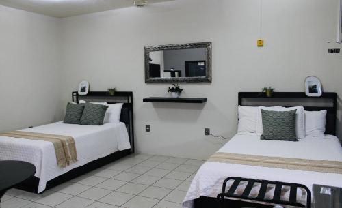 a bedroom with two beds and a mirror on the wall at Preciados Loft Cold AC best WIFI in Tequila
