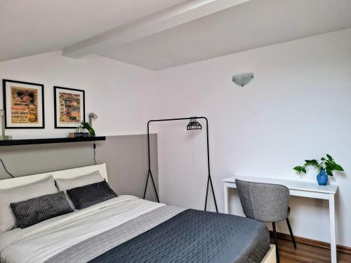 a bedroom with a bed and a desk and a chair at Casa de pe colț in Orăştie