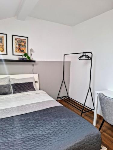 a bedroom with a bed and a white wall at Casa de pe colț in Orăştie