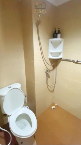 ein Badezimmer mit weißer Toilette und Dusche in der Unterkunft Margonda Residence 5 Depok by Sahaja Stay in Kemirimuka Tiga
