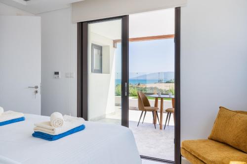 a bedroom with a bed and a sliding glass door at Santa Barbara Sea front resort and spa in Polis Chrysochous
