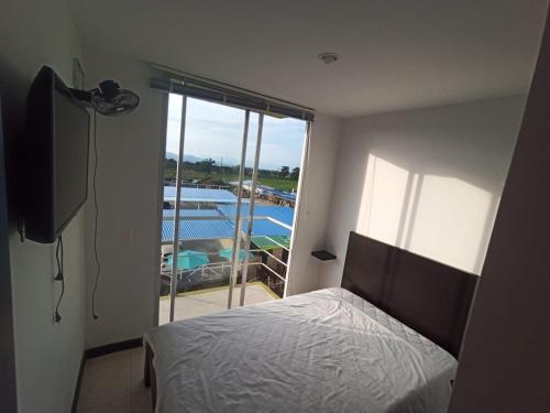 a bedroom with a bed and a view of a pool at Lindos Apartamentos Economicos en el Eje Cafetero in Montenegro