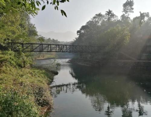 a bridge over a river with a bridge over a river at Devas Riverside Homestay in Kallar-Bridge