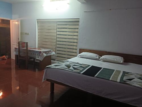 a bedroom with a bed and a table and a dining room at Devas Riverside Homestay in Kallar-Bridge