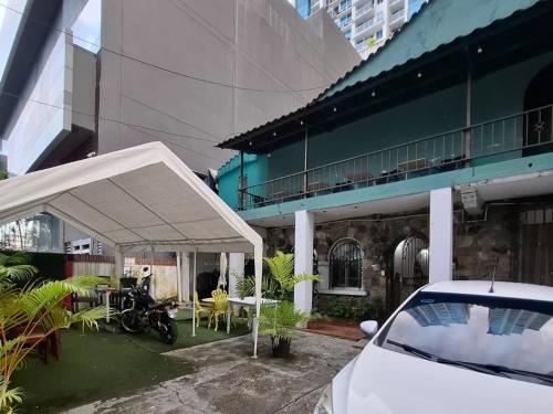 Una carpa blanca frente a un edificio con una motocicleta. en Hostel the pod 33, en Panamá