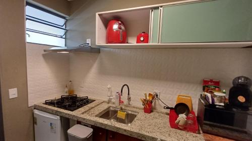 a kitchen counter with a sink and a stove at Studio Barreto Leme Ap72 in Campinas