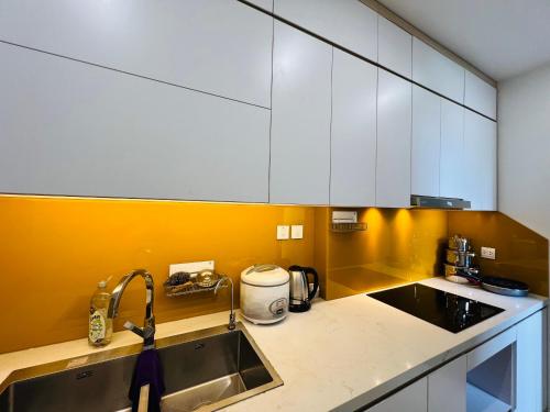 une cuisine avec des armoires blanches et un évier dans l'établissement Vinhome D'capitale - Tran Duy Hung, à Hanoï