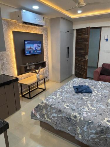 une chambre avec un lit et une télévision sur un mur dans l'établissement Orchid by Oasis Homestays, à Jaipur