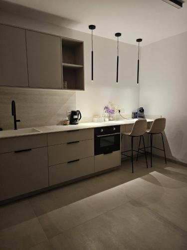 a kitchen with white cabinets and a table and chairs at מנות בטבע in Manot