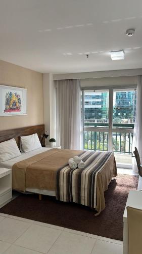 a bedroom with a large bed and a large window at Maravilhoso Flat Vision in Brasilia