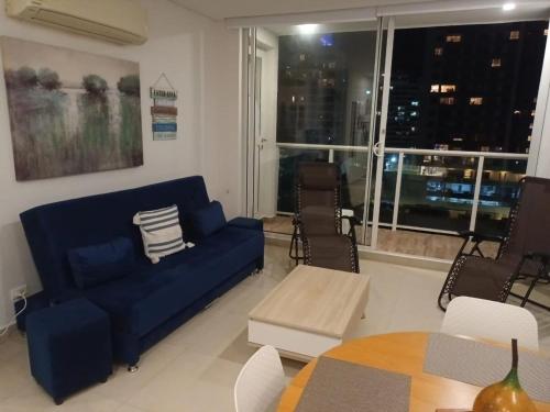 a living room with a blue couch and a table at APARTAMENTO VISTA AL MAR WIND 906 in Gaira