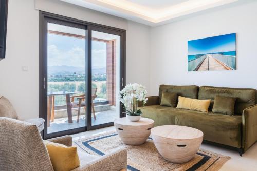 a living room with a couch and a table at Santa Barbara Sea front resort and spa in Polis Chrysochous