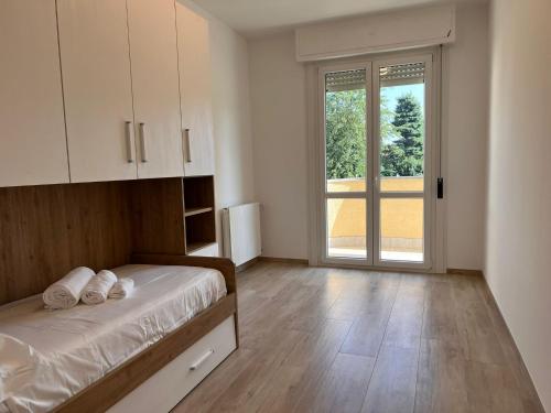 a bedroom with a bed and a large window at Kìbilù Comfort Hub Malpensa in Cardano al Campo