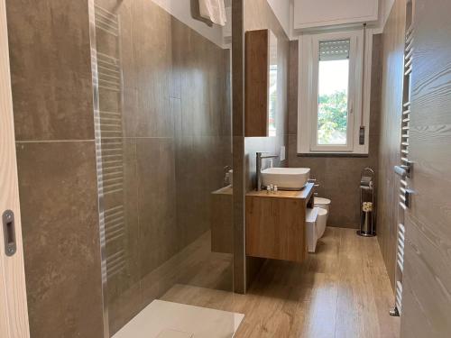 a bathroom with a sink and a toilet and a shower at Kìbilù Comfort Hub Malpensa in Cardano al Campo