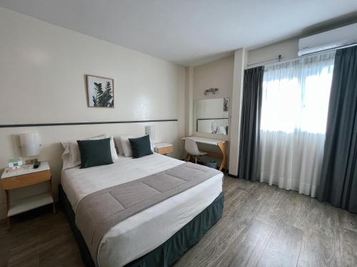 a hotel room with a large bed and a window at Alpino Hotel in Buenos Aires
