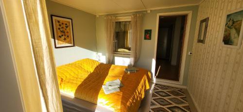 a bedroom with a bed with a yellow comforter at Marias Guesthouse in Tromsø