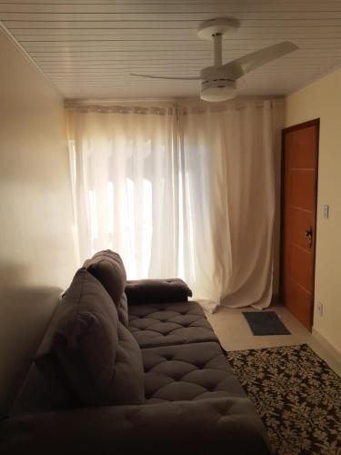 a living room with a couch in front of a window at Apartamento mobiliado in Itabuna
