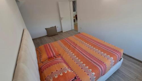 a bed in a room with an orange and orange blanket at Villa Alpine in Valjiosi