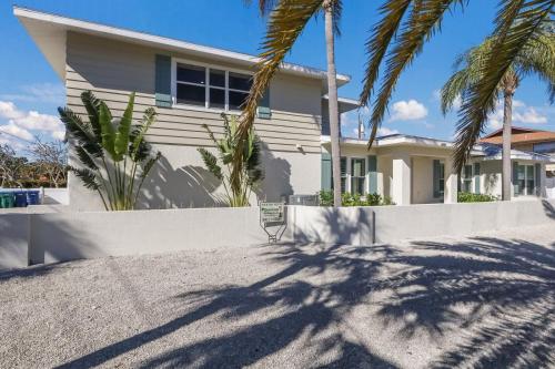 a house with palm trees in front of it at Surf Riders home in Holmes Beach