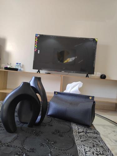 a black purse sitting on the floor in front of a television at وادي العقيق 202 in Al Madinah