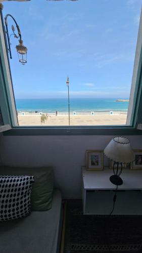 a room with a window with a view of the beach at Résidence artistique Vue sur mer in Larache