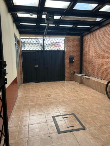 a garage with a black door and a tile floor at AShostEcuador, Quito, rooms & suits, Quito cerca parque La Carolina in Quito
