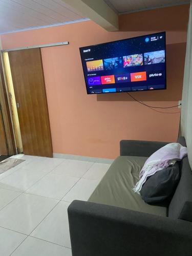 a living room with a couch and a flat screen tv at Recanto Marina in Paraty