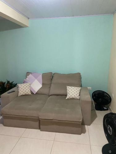 a living room with a brown couch in a room at Recanto Marina in Paraty