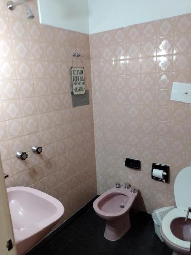 a bathroom with a pink toilet and a sink at Habitación Matrimonial Privada in San Carlos de Bariloche