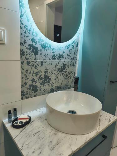 a bathroom with a sink and a mirror at Aura Apartamenty in Brzeg