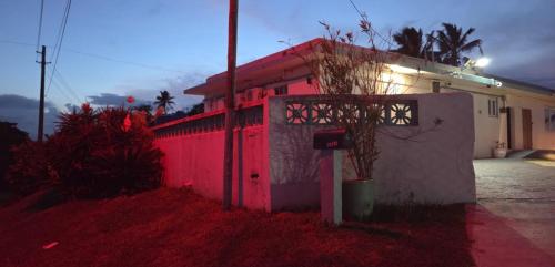a house with a pink wall and a fence at Ventana Va102b at Arecibo 681 Ocean Drive in Arecibo
