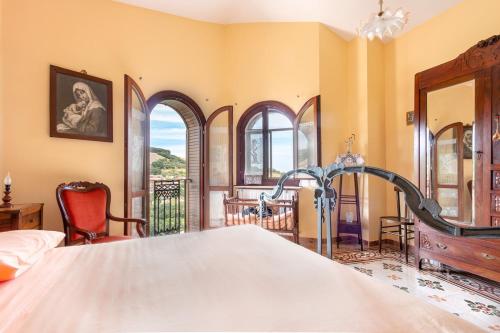 a bedroom with a large bed and some windows at Casa Bizzarro in Deliceto