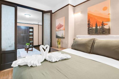 a bedroom with two swans sitting on a bed at Unbeatable Location The Heart of NYC 1 BDR W GYM in New York