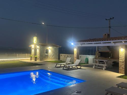 a swimming pool in a backyard at night at Costa Kalamos Suites in Kalamos