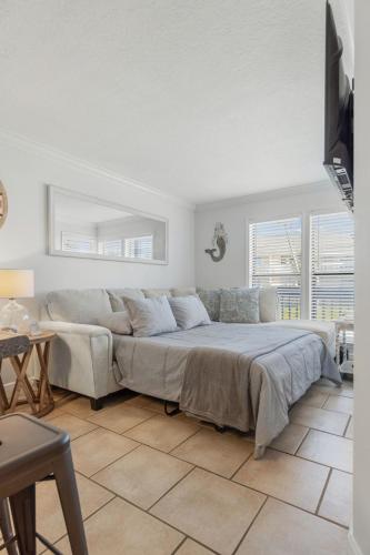 a bedroom with a bed and a couch and windows at Sandpiper Cove 8140 - 500 Feet to the Beach! Pool in the Back Yard! in Destin