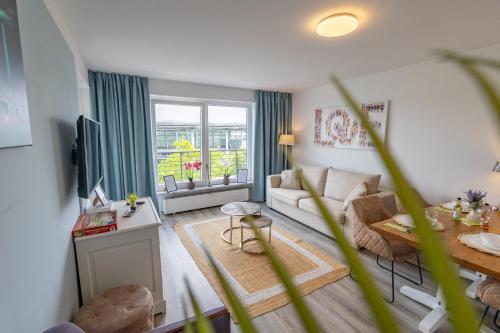a living room with a couch and a table at HANNIBAL - Design City Apartments - "Südkopcenter", VW Nähe, Parkplatz, HighSpeed-WLAN, Fitness, Gastronomie, Balkon oder Terrasse in Wolfsburg