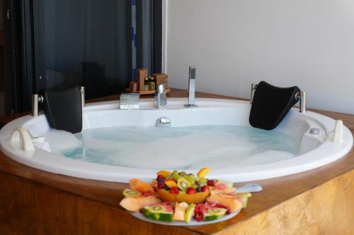 un bagno con una vasca con dentro un piatto di frutta di vice city beach resort otel a Arpaçbahşiş