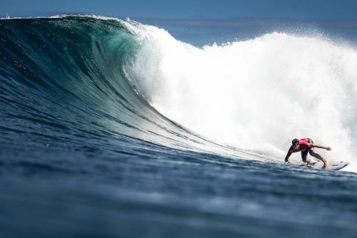 a man riding a wave on a surfboard in the ocean at Ventana Va102b at Arecibo 681 Ocean Drive in Arecibo
