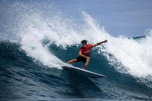 a man riding a wave on a surfboard in the ocean at Ventana Va102b at Arecibo 681 Ocean Drive in Arecibo