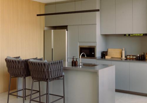 a kitchen with two bar stools and a counter at Season Hill Khao Yai in Ban Nong Song Hong