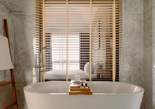 a white bath tub in a bathroom with a window at Season Hill Khao Yai in Ban Nong Song Hong