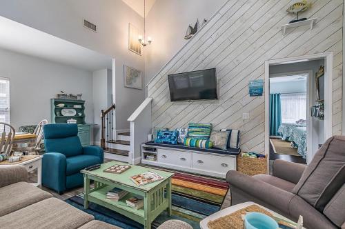 a living room with a couch and a tv at Charming Coastal Retreat on Fripp Island - 3BR/3BA with Golf Course Views in Fripp Island
