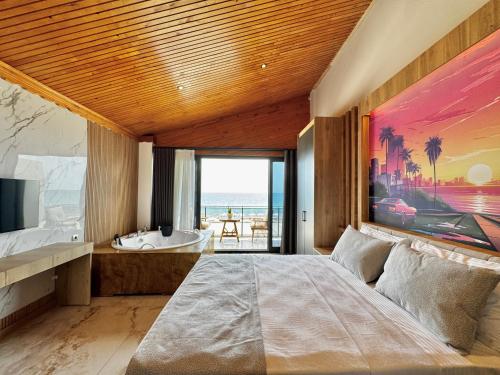 una camera con un grande letto e una vista sull'oceano di vice city beach resort otel a Arpaçbahşiş