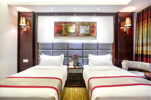 a hotel room with two beds and a table at Bengal Blueberry in Dhaka