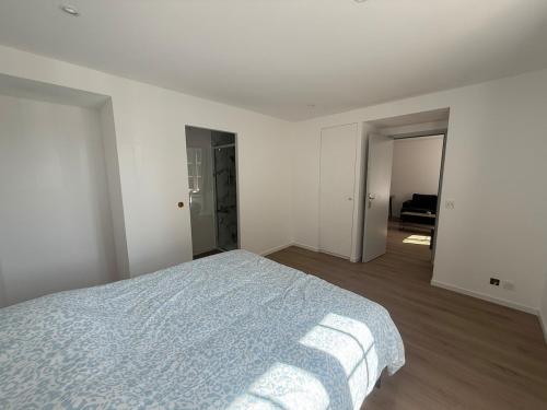 a white bedroom with a bed with a blue blanket at Appartement T2 Neuf Pont-Réan in Guichen
